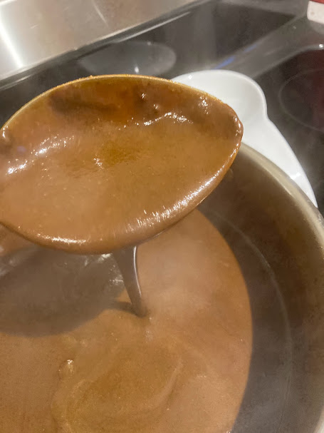 hot, steaming mole pouring from a large spoon